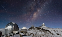 In the outskirts of the Atacama Desert, far from the light-polluted cities of northern Chile, the skies are pitch-black after sunset. Such dark skies allow some of the best astronomical observing to take place — and at an altitude of 2400 metres, ESO’s La Silla Observatory has an incredibly clear view of the night sky. However, even such a remote, high, and dry location cannot always escape the weather that sometimes comes with the winter months, when blankets of snow can cover the mountain peak and its telescope domes. This image shows a wintry La Silla sitting beneath a spray of stars from our Milky Way, the plane of which slants across the frame. Visible (from right to left) are the ESO 3.6-metre telescope, the 3.58-metre New Technology Telescope (NTT), the ESO 1-metre Schmidt telescope, and the MPG/ESO 2.2-metre telescope, which has snow on its dome. The small dome of the decommissioned Coudé Auxiliary Telescope can be seen adjacent to that of the ESO 3.6-metre telescope, and between it and the NTT are the water tanks of the observatory. While the sight of snow at La Silla may initially be surprising, the high altitude ESO sites can experience both hot and cold temperatures through the year, and occasionally be subject to harsh conditions. This photograph was taken by José Francisco Salgado, an ESO Photo Ambassador.