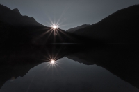 peaking_sun_in_lake_by_eberhard_grossgasteiger